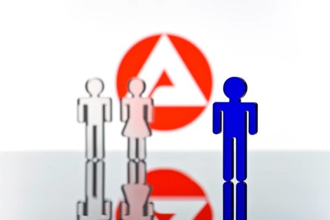 Three figures standing in front of the logo of the German employment agency