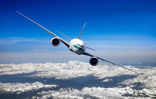 Cathay Pacific Boeing 777-367 ER in flight over mountains