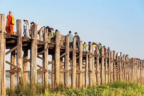 Locals and tourists on a teak bridge
