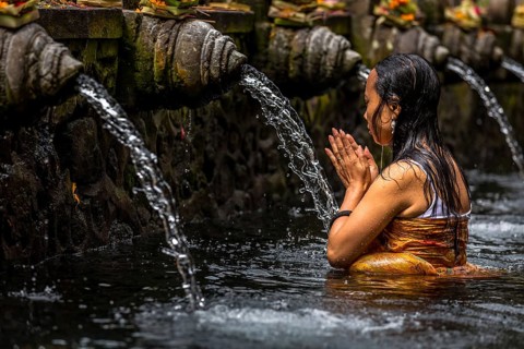 Woman praying in a purifying pool