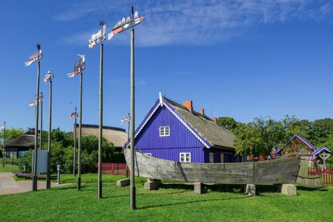 Curonian flags in front of traditional wooden houses