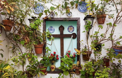 Corner with many potted plants and a cross