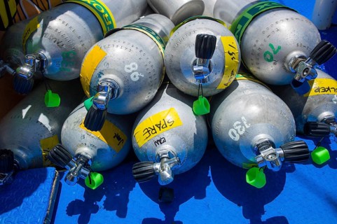 Compressed air cylinders or scuba tanks lying in a diving boat