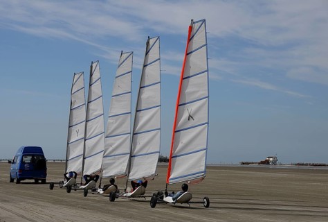 Land yachts being pulled to the beach by a car