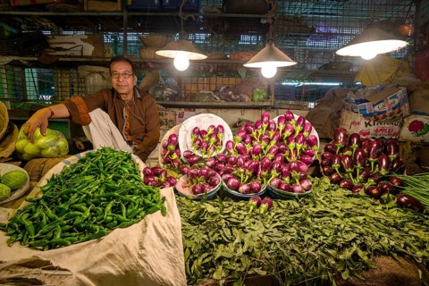 Man selling vegetables at a vegetable market