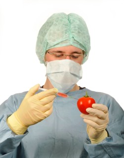 Chemist in sterile scrubs holding a syringe and a tomato