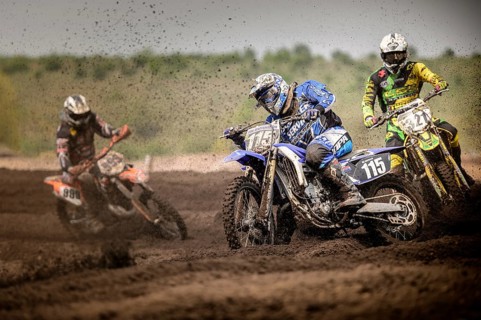 Three motocross riders on a track during a race
