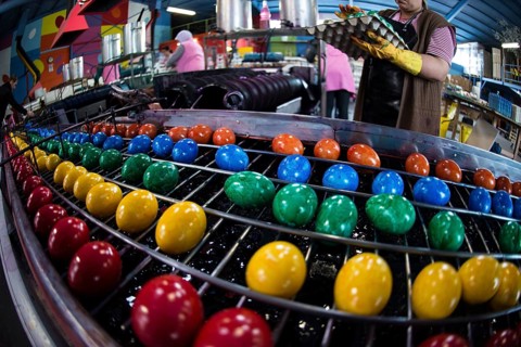 Brightly coloured Easter eggs on a conveyor belt