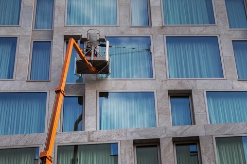 Window cleaner cleaning the windows of a hotel