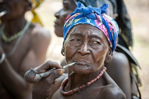An elderly woman from the Koma people smoking a pipe