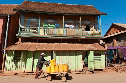 Man pushing goods on home-made cart