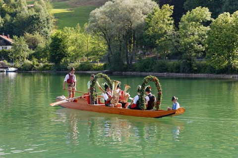 Locals wearing traditional costumes in a decorated wooden Platte boat