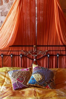 Romantic metal bed with canopy and two oriental silk cushions