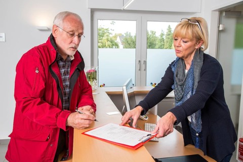 Patient filling in a form at the reception of a dental office
