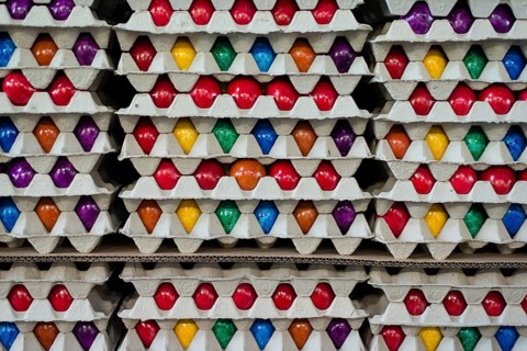Brightly colored Easter eggs stacked in cardboard boxes
