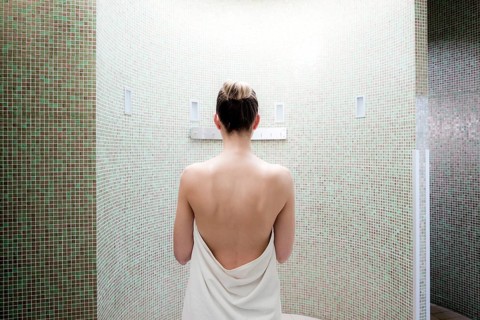 Woman standing in a steam room of a spa complex