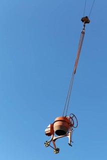 Concrete mixer hanging from a crane