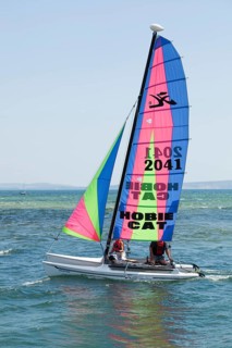 Two people sailing on a Hobie Cat catamaran