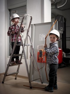 Twins with hard hats at play as construction workers