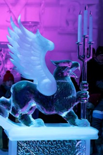 Griffin figure made of ice holding candlesticks made of ice