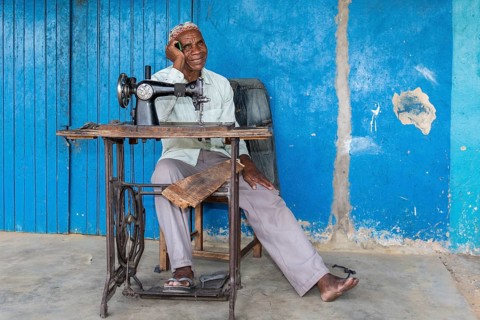 Tailor sitting in front of his shop in Kalabo
