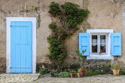 Light blue door and window with light blue shutters