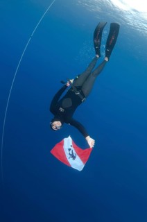 Freediver holds a diver down flag