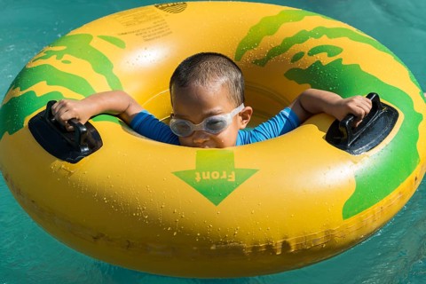 Boy playing with a floating tire