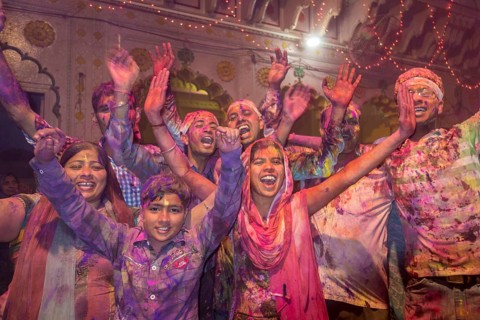 Devotees covered in coloured powder celebrating