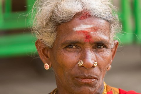 Elderly local woman with a bindi on her forehead wearing gold jewelry