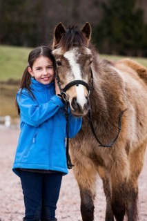 Girl standing beside a pony