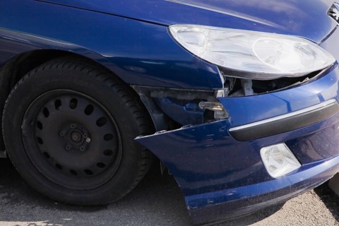 Blue compact car with an accident-damaged front bumper
