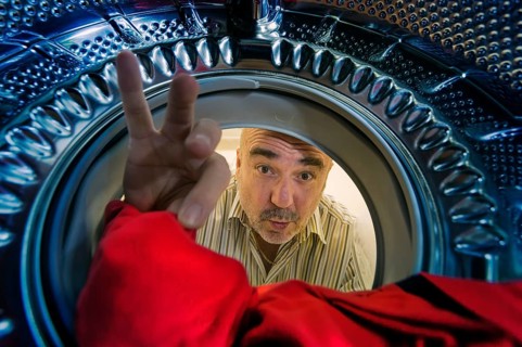 Man looking into a washing machine