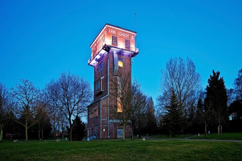 The illuminated Hammerkopfturm tower of Zeche Erin Colliery at dusk