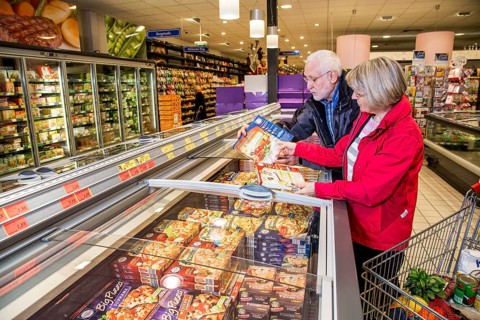 Senior couple shopping in the frozen food section in a supermarket