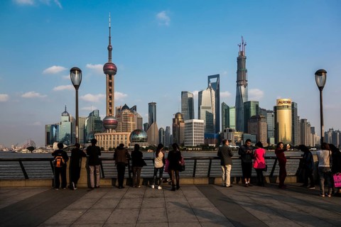 Tourists in front of the Pudong skyline with Oriental Pearl Tower