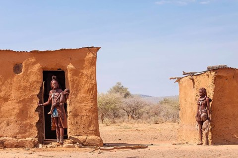 Himba women with children in front of their mud huts
