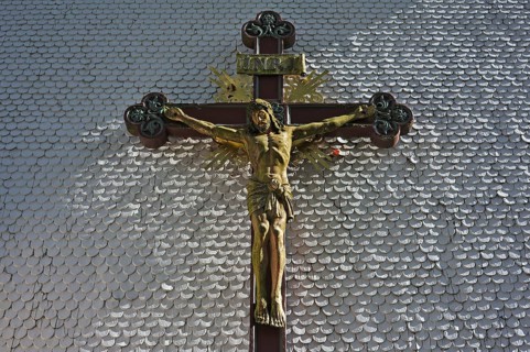 Carved wooden crucifix on the shingle facade of the parish church of St. Margaret