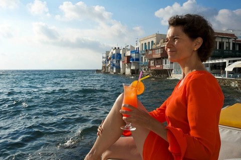 Woman enjoying a cocktail and a view over the sea