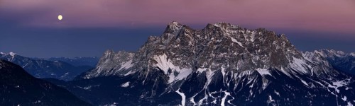 Summit of Mt Zugspitze with a full moon at dusk