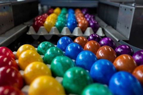 Brightly coloured Easter eggs on a conveyor belt