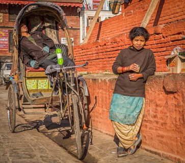Rickshaw driver and a woman taking a rest