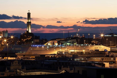 The Lighthouse of Genoa with cruise ship in the Porto Antico harbour