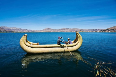 Two local in a traditional rowing boat of Totora reed on Lake Titicaca