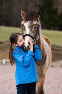 Girl cuddling with a pony
