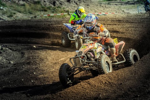 Two quad bikes speeding through a curve on a motocross track