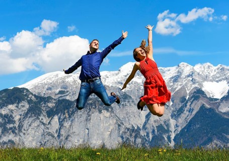 Man and woman jumping on a meadow