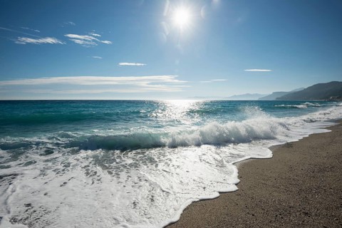 Waves on the beach with the sun