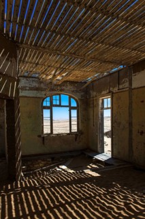 Light passing through the laths of a decaying house in the former diamond miners settlement that is slowly covered by the sand of the Namib Desert
