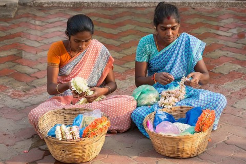 Two girls producing floral decorations to sell them later
